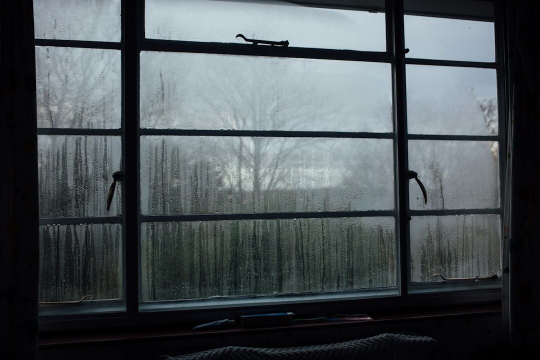 Old wooden writing desk with a typewriter, candle and foggy window