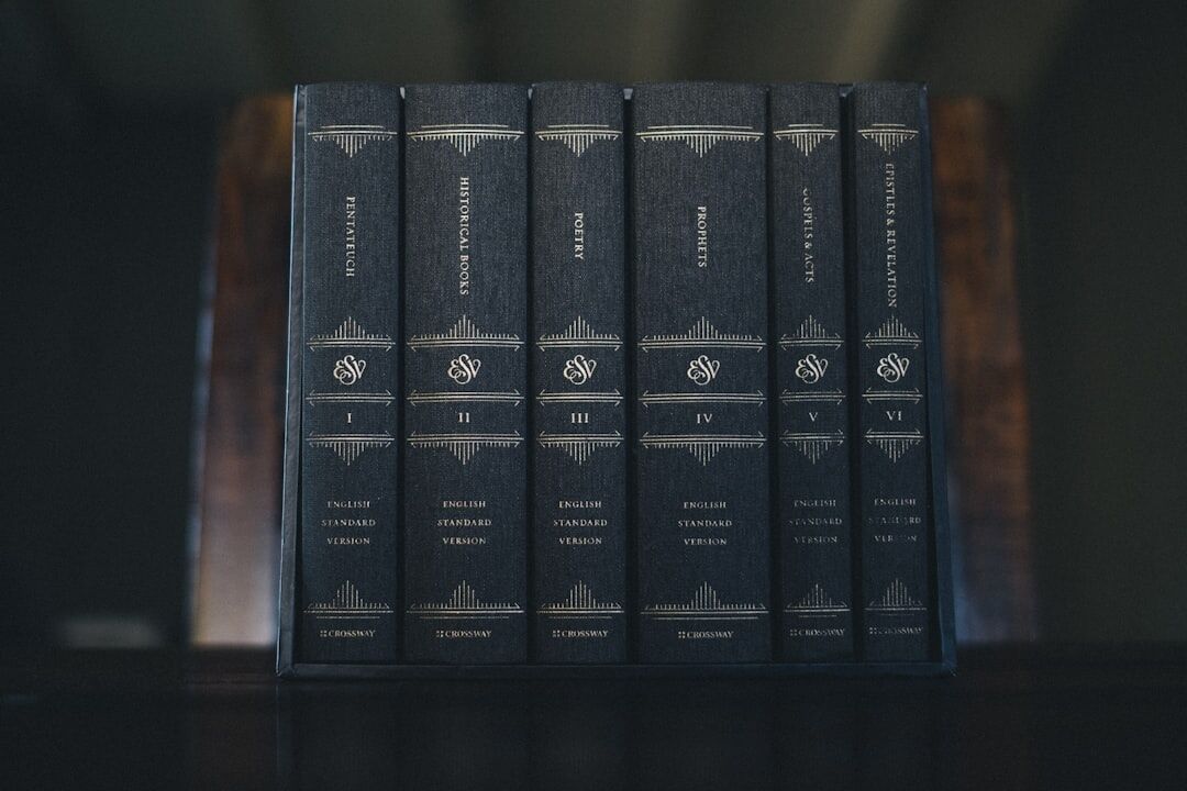 Stack of old hardcover mystery novels on a wooden table